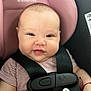 baby, car_seat, smiling, face, child, infant, seatbelt, clothing, safety, pink, black_strap, cute, portrait, person, indoors, young_child, happy, closeup, head, hand