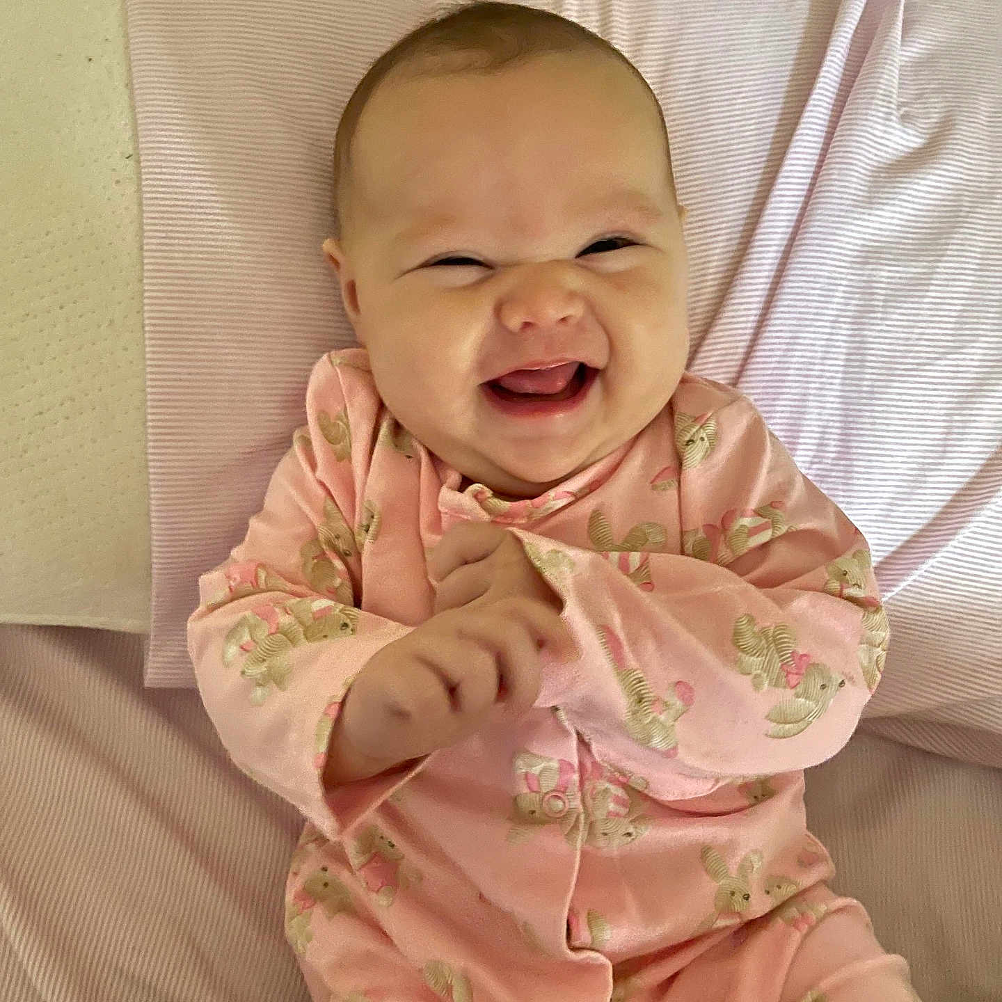 Ariadna Ceslete is registered to the contest to win money with this photo: baby, blanket, bunny_print, child, clothing, cute, expressive, face, hands, happy, indoors, infant, laughing, lying_down, pink_onesie, playful, portrait, smiling, soft_texture, young_child