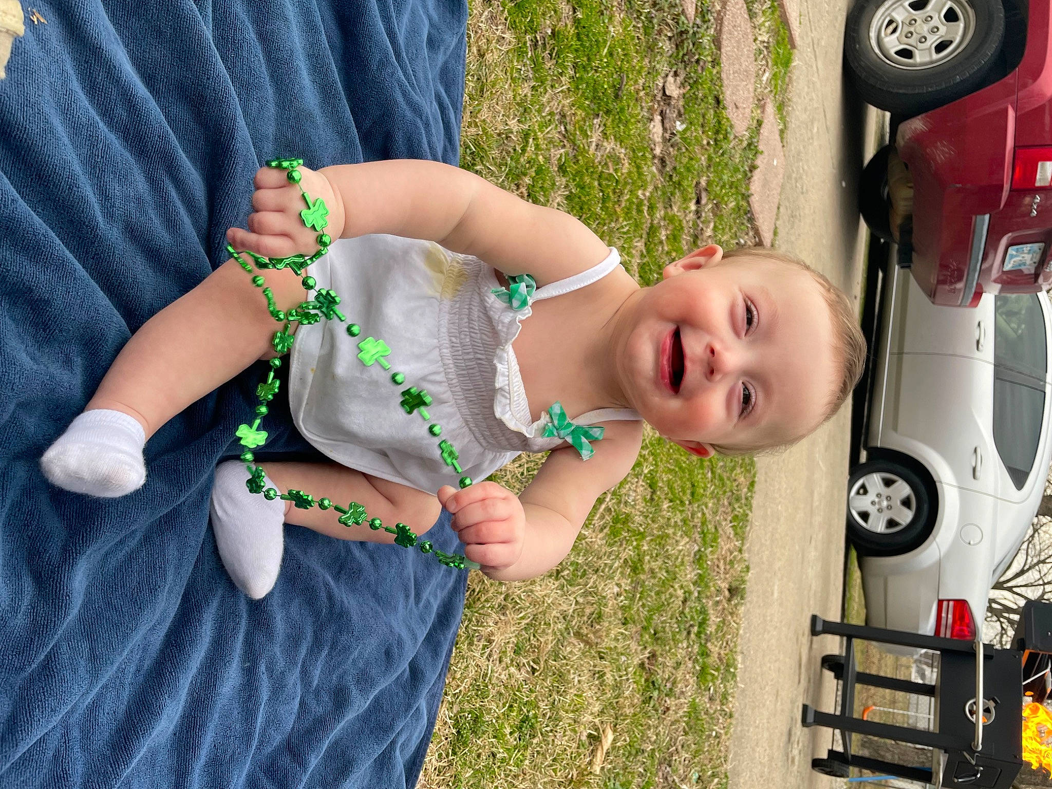 Joslynn is registered to the contest to win money with this photo: arm, automotive_exterior, automotive_lighting, automotive_tire, car, child, clothing, fender, finger, grass, hand, happy, joy, motor_vehicle, person, plant, sunglasses, tire, toddler, vehicle