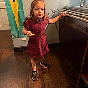Rita Valentina joined the competition — help win amazing prizes! child, girl, toddler, portrait, standing, smiling, dress, burgundy_dress, sneakers, snack, piano, musical_instrument, indoor, wooden_floor, flag, colorful_flag, home, face, long_hair, playful