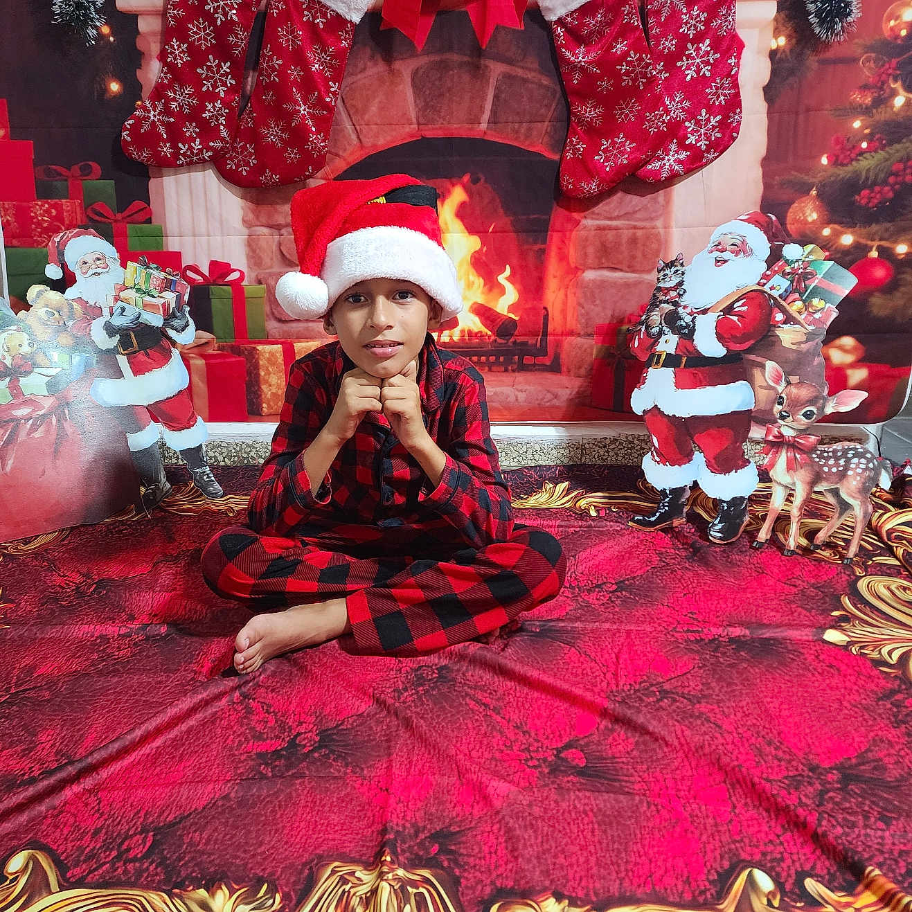Keylor Jam is registered to the contest to win money with this photo: celebration, child, christmas, christmas_decorations, cute, decor, festive, fireplace, gifts, holiday, holiday_season, holiday_theme, indoor, pajamas, pose, red_carpet, santa_hat, sitting, smiling, stockings