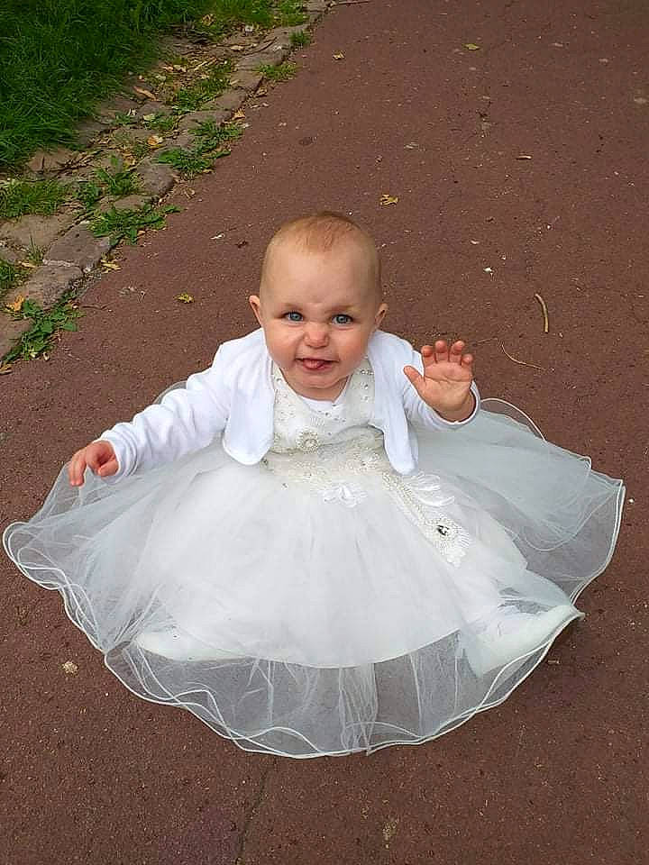 Tyana a rejoint le concours — aidez-le/la à gagner de superbes lots ! arm, baby, baby_toddler_clothing, bridal_accessory, bridal_clothing, chin, dress, embellishment, face, flash_photography, grass, hair, happy, head, headgear, headpiece, human_body, iris, person, smile