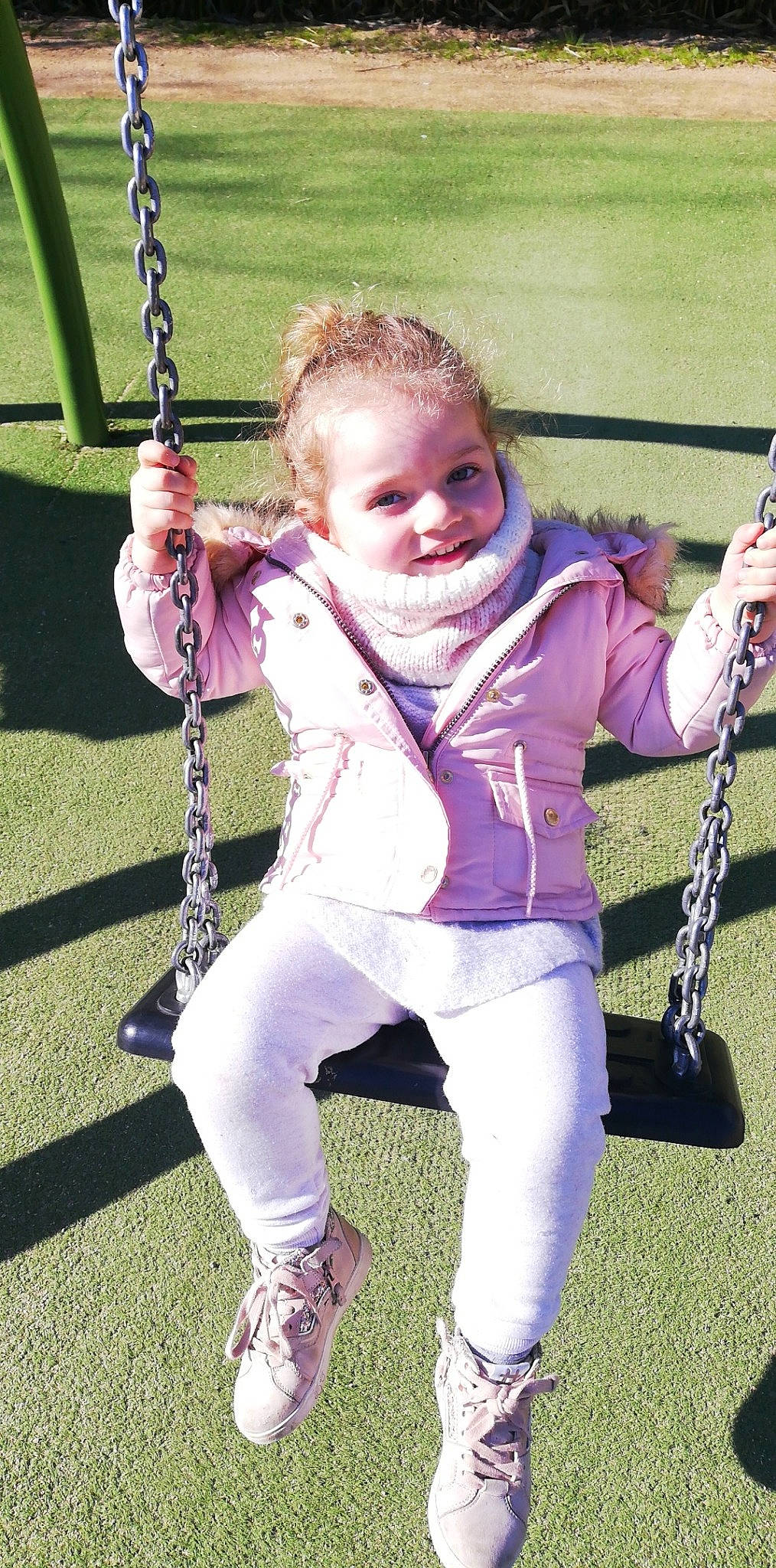 Emmy a rejoint le concours — aidez-le/la à gagner de superbes lots ! arm, child, city, electric_blue, fun, grass, happy, knee, leg, leisure, outdoor_play_equipment, person, pink, playground, purple, recreation, sitting, smile, swing, toddler