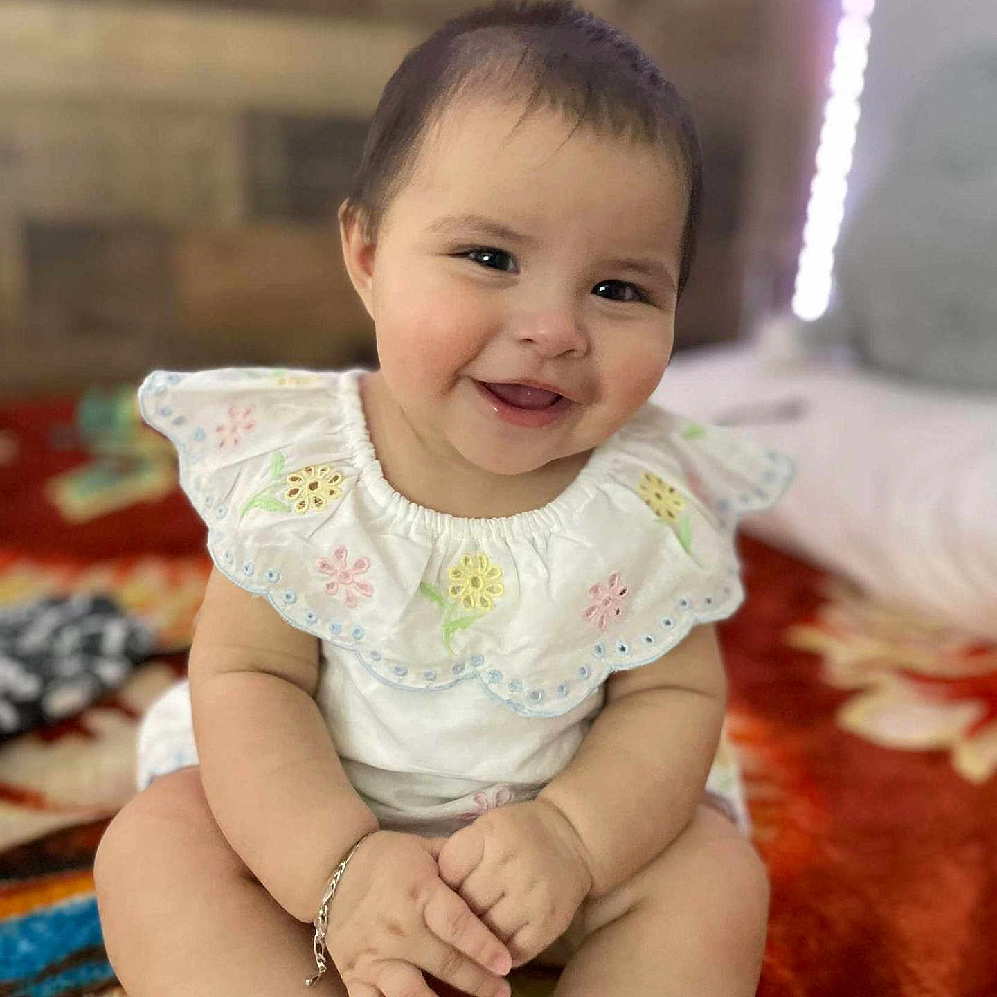 Bela is registered to the contest to win money with this photo: adorable, baby, blanket, bracelet, child, colorful, cute, face, floral_embroidery, hands, happy, indoors, infant, lace, portrait, sitting, smiling, sock, soft_light, white_dress