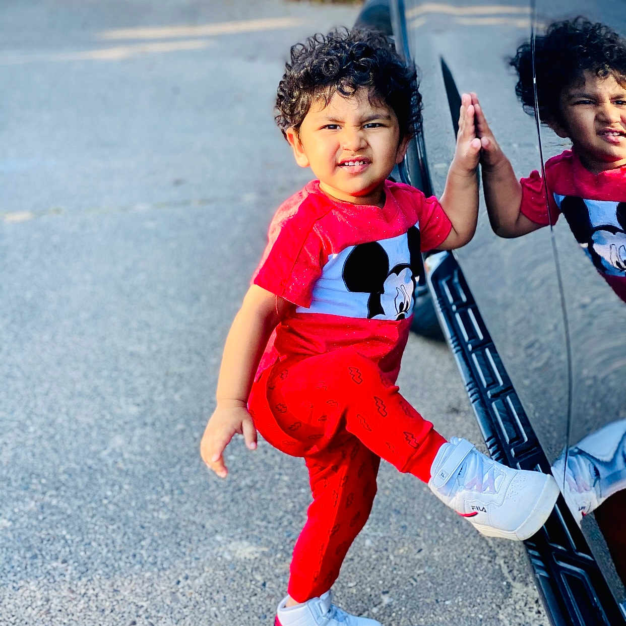 Gursahib Singh joined the competition — help win amazing prizes! car, child, curly_hair, daylight, expression, funny_face, mickey_mouse, outdoor, pajamas, person, playful, pose, red_clothing, reflection, sidewalk, smile, sneakers, standing, toddler, white_shoes