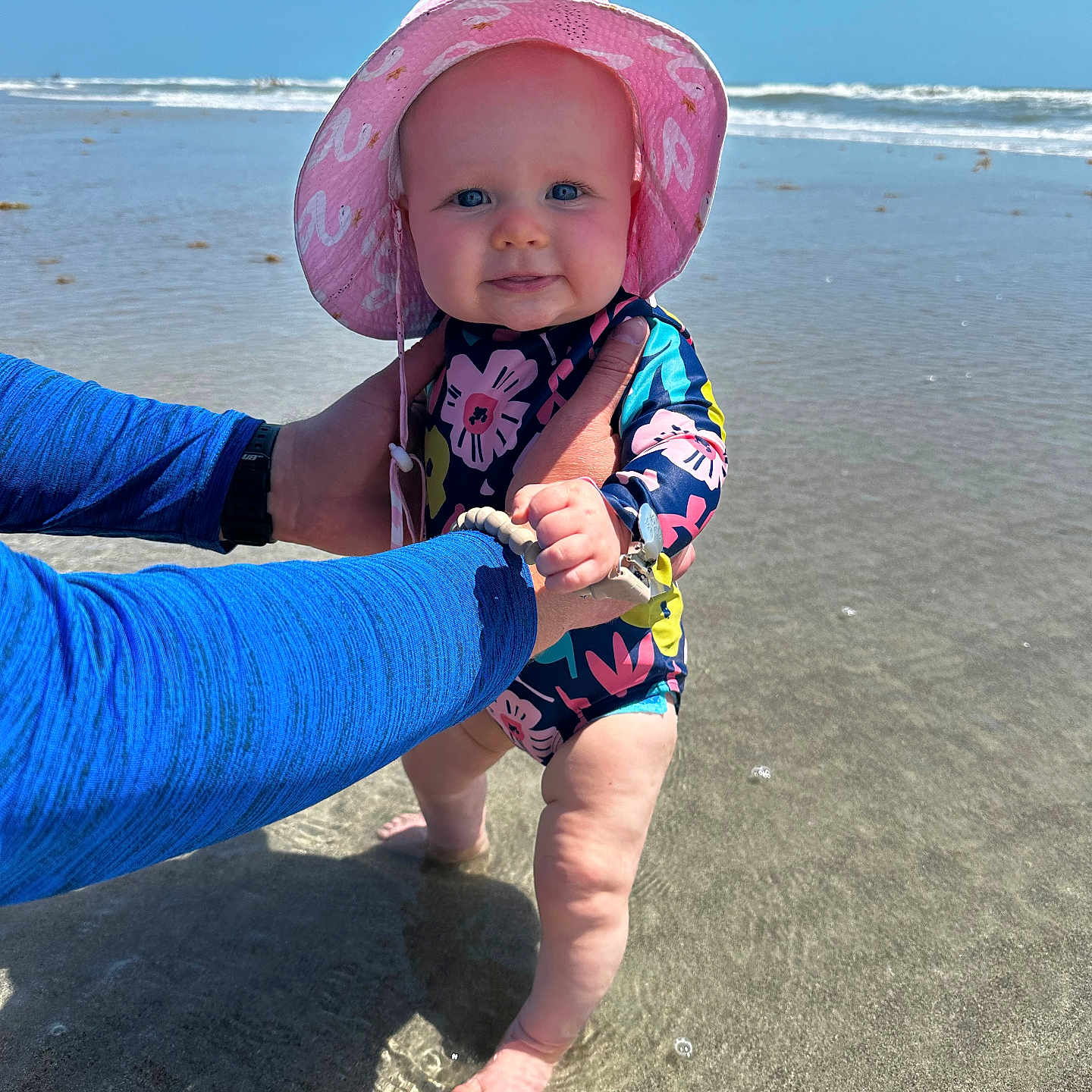 Emery is registered to the contest to win money with this photo: accessories, baby, beach, clothing, coast, face, hat, head, nature, outdoors, pants, person, photography, portrait, sea, shoreline, soil, summer, sunhat, water
