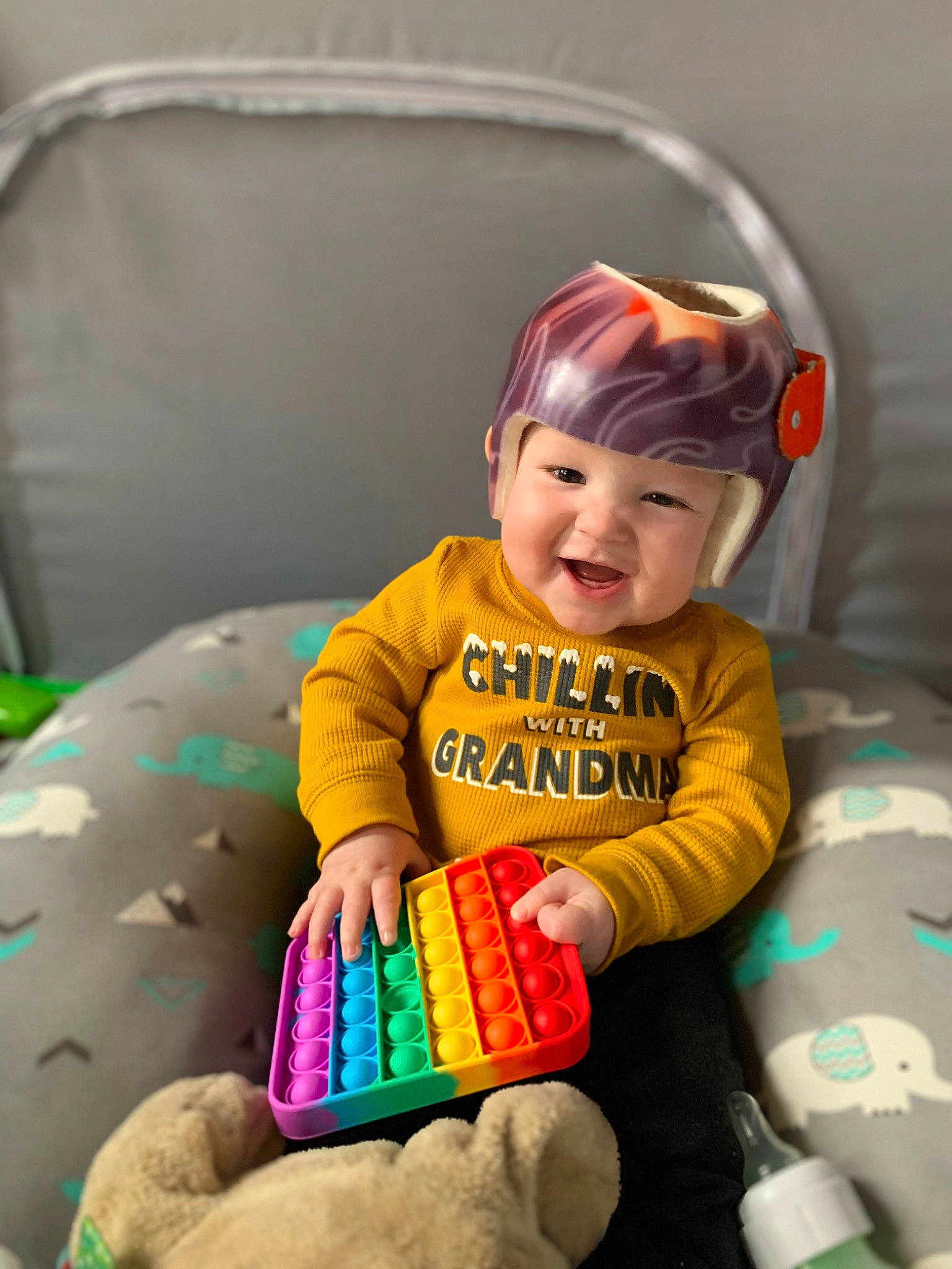 Noah is registered to the contest to win money with this photo: baby, baby_playing_with_toys, baby_products, baby_toddler_clothing, child, comfort, eye, face, finger, fun, goggles, hand, happy, head, headwear, human_body, person, sitting, smile, sock