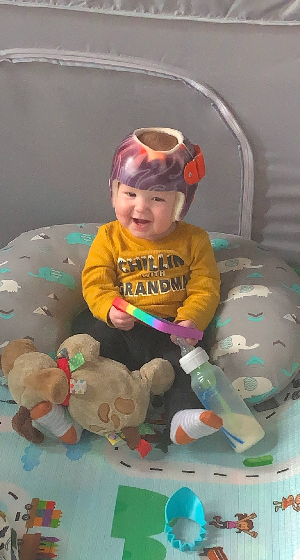 Noah is registered to the contest to win money with this photo: baby, baby_products, baby_toddler_clothing, cap, child, comfort, facial_expression, flooring, fun, goggles, happy, headwear, person, personal_protective_equipment, play, room, sitting, sleeve, smile, sunglasses