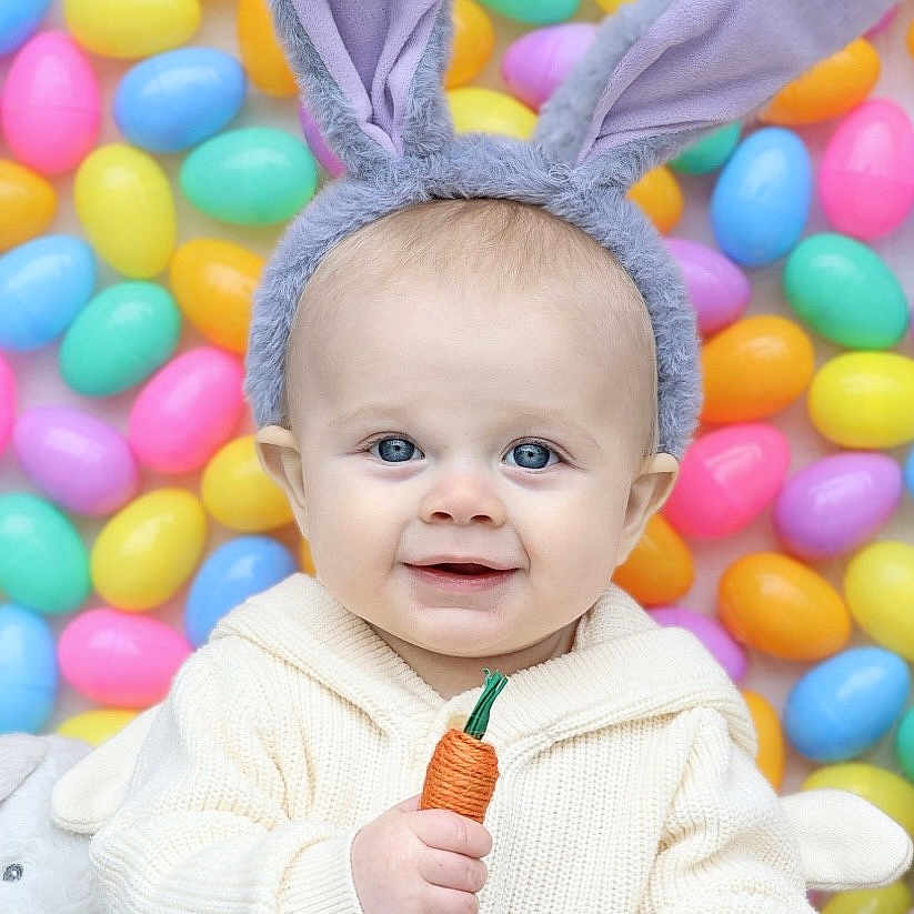 Pierce is registered to the contest to win money with this photo: baby, bunny_ears, carrot_toy, child, colorful, cute, easter_eggs, festive, funny_hat, happy, indoors, kid, pastel_colors, playful, portrait, smiling, toy, wearing_hat, white_sweater, young_child