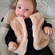 Leya participe au concours pour gagner de l'argent avec cette photo : baby, infant, fur_vest, black_clothing, baby_seat, cushion, dandelion_pattern, face, eyes, hands, cozy, cute, portrait, indoor, soft_lighting, child, young_baby, comfortable, expression, person