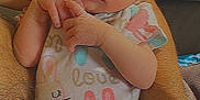Josephine joined the competition — help win amazing prizes! baby, infant, newborn, arms, tattoo, onesie, clothing, sleepy, cute, hands, legs, skin, person, closeup, love, bunny_print, peaceful, holding, family, cuddle