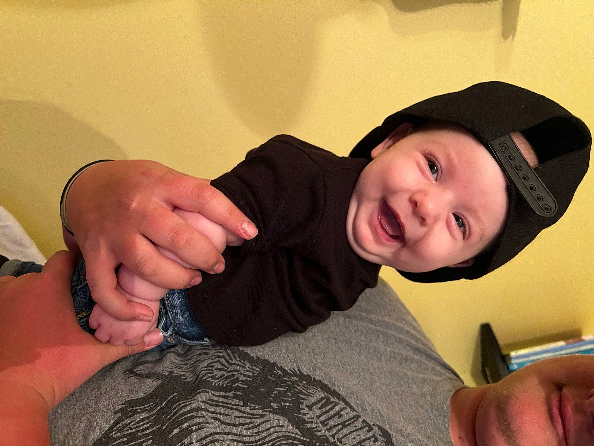 Blaise is registered to the contest to win money with this photo: black_hair, cap, cheek, comfort, elbow, finger, flash_photography, gesture, happy, headwear, human_leg, joint, knee, mouth, neck, person, sleeve, smile, t_shirt, thigh