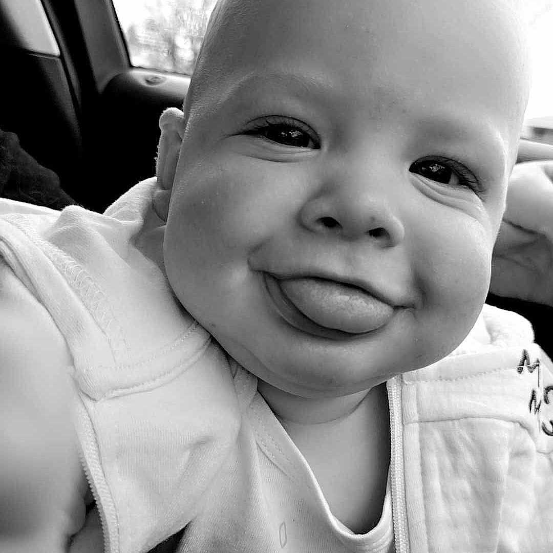 Skylar joined the competition — help win amazing prizes! baby, babylaughing, bodypart, clothing, coat, cushion, face, finger, hand, happy, head, homedecor, jacket, laughing, mouth, person, photography, portrait, smile, teeth