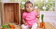 Azori joined the competition — help win amazing prizes! baby, child, pink_clothing, floral_leggings, sitting, decorative_carrots, wooden_basket, woven_mat, indoor, window, garden_background, curly_hair, bow, floor, cute, portrait, expression, natural_light, home_decor, toy