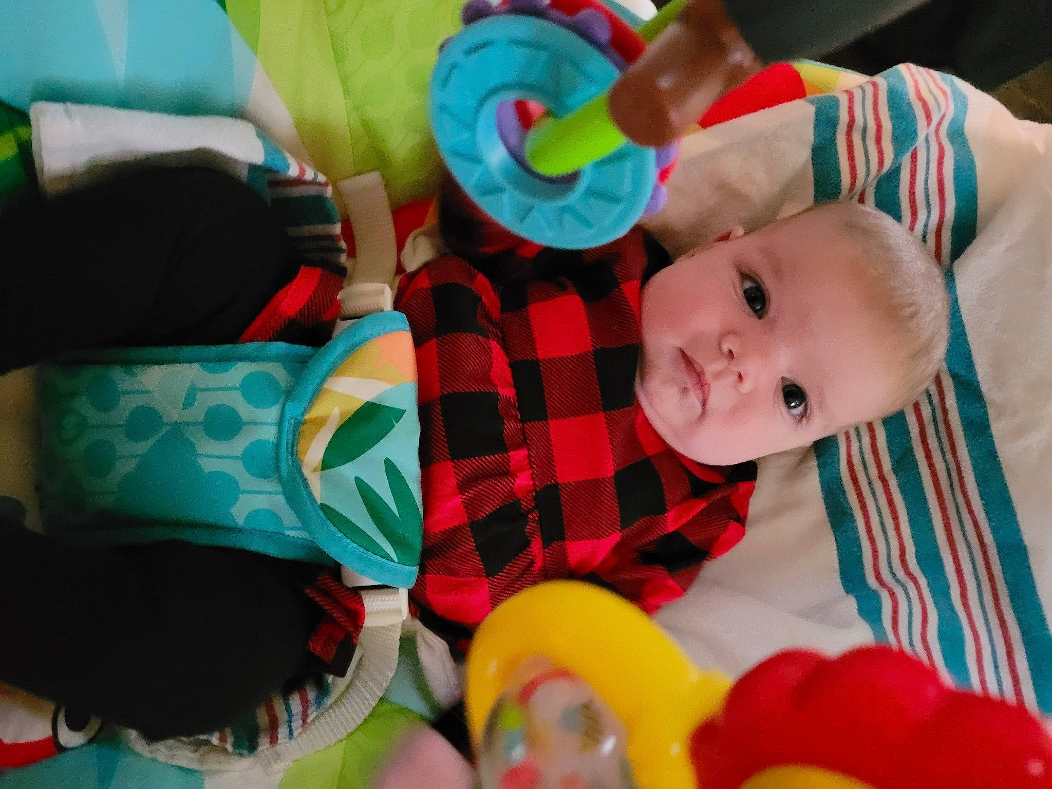 Rylee is registered to the contest to win money with this photo: baby, baby_playing_with_toys, baby_products, baby_toddler_clothing, child, comfort, event, eye, fun, green, happy, linens, orange, pattern, person, plaid, product, red, textile, toddler