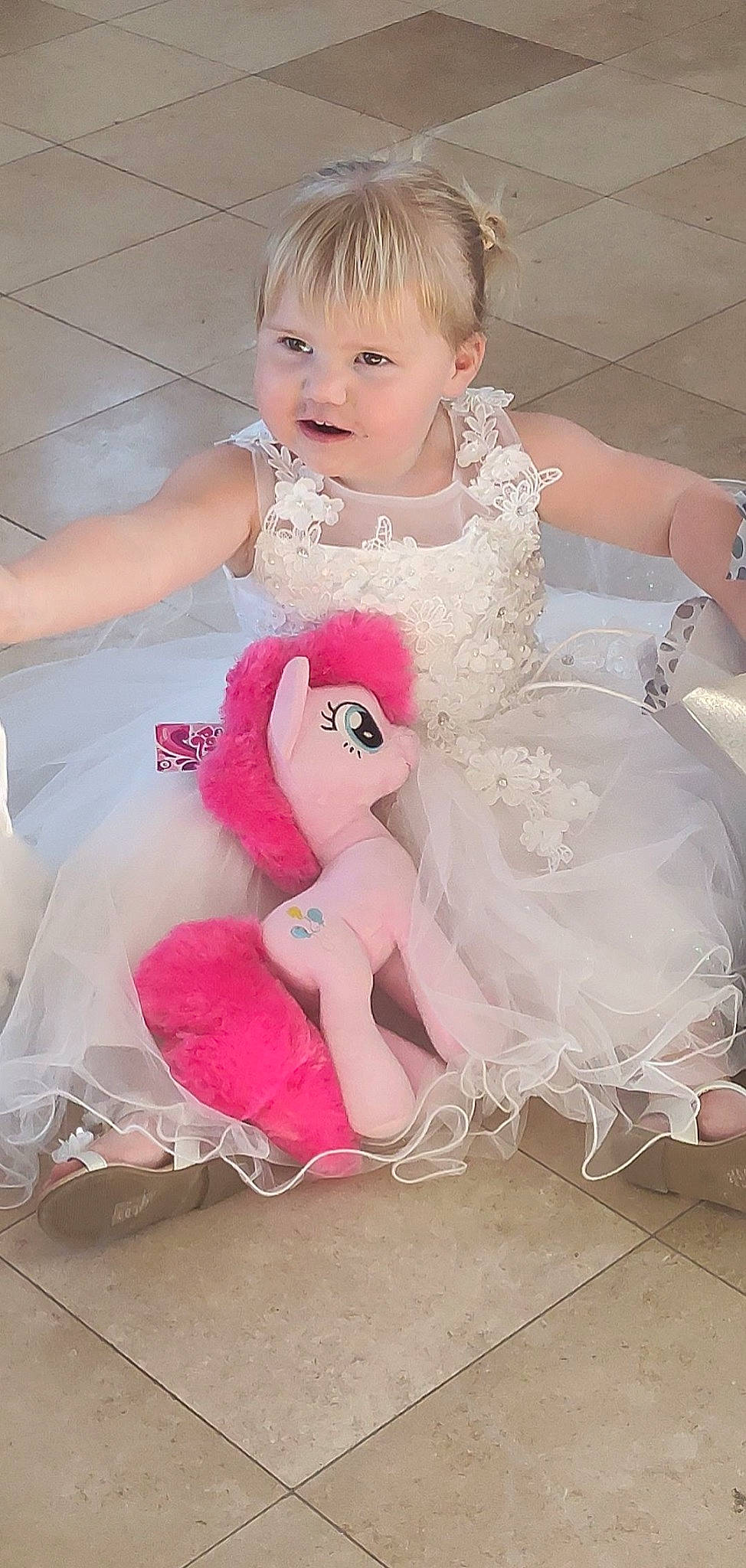 Kelia participe au concours pour gagner de l'argent avec cette photo : bridal_accessory, bridal_clothing, child, doll, dress, embellishment, eyelash, fashion_design, gown, hairstyle, happy, headgear, headpiece, person, pink, ruffle, shoulder, skin, smile, textile