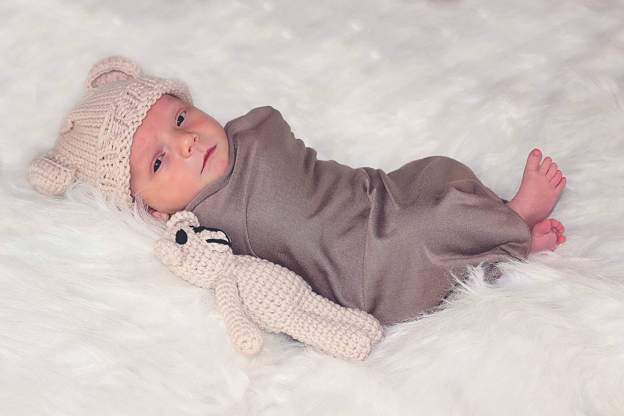 Cayson is registered to the contest to win money with this photo: baby, baby_toddler_clothing, cheek, child, comfort, eye, face, flooring, fur, grass, happy, head, headwear, human_body, linens, pattern, person, sitting, skin, sleeve
