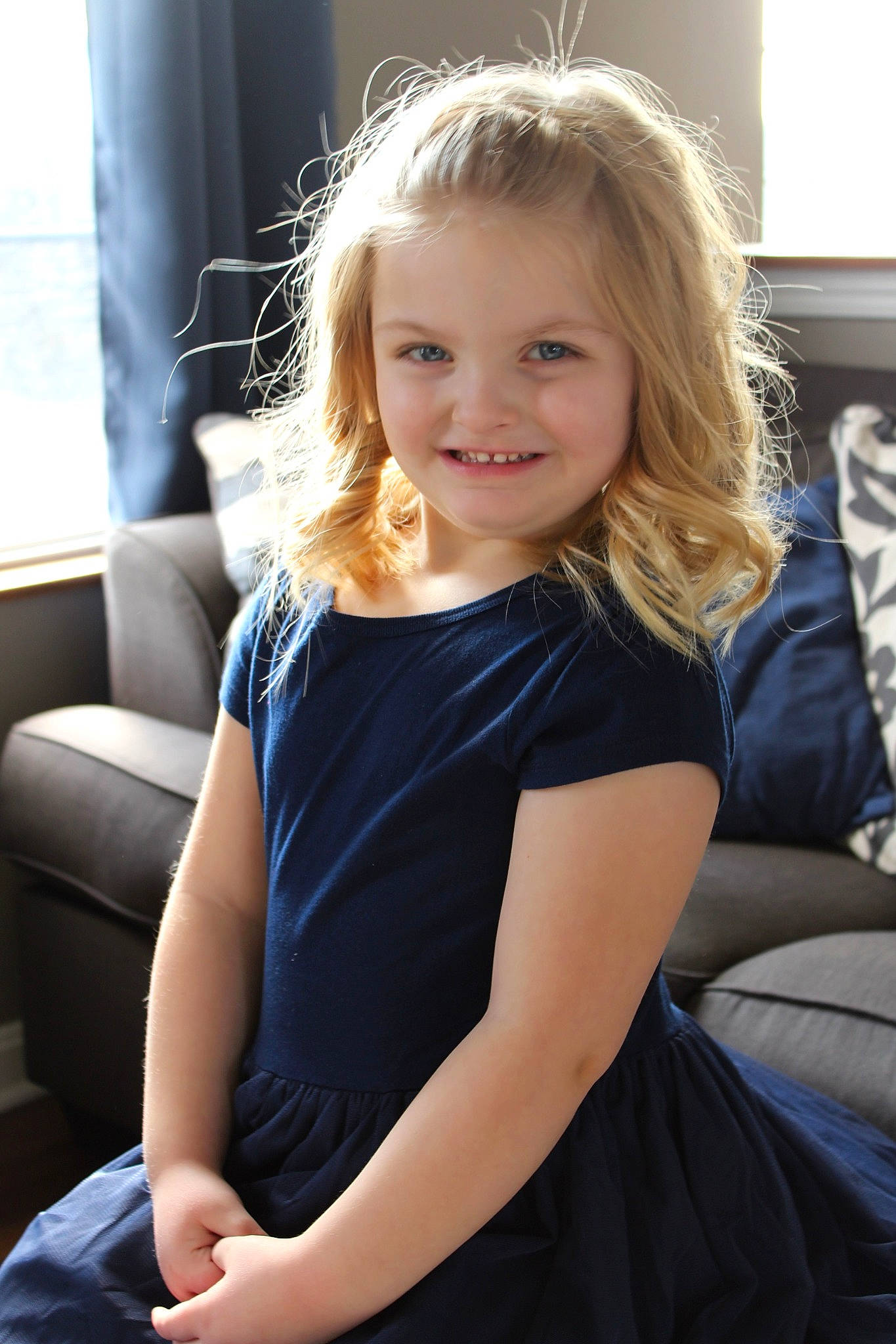 Macy is registered to the contest to win money with this photo: arm, beauty, blond, brown_hair, child, child_model, couch, dress, face, hair, hairstyle, joy, leg, long_hair, person, photography, shoulder, sitting, smile, toddler