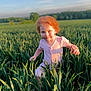 child, red_hair, pink_dress, field, greenery, grass, outdoor, sunlight, nature, happy, playful, blue_sky, young_girl, summer, smiling, portrait, daylight, cute, person, environment
