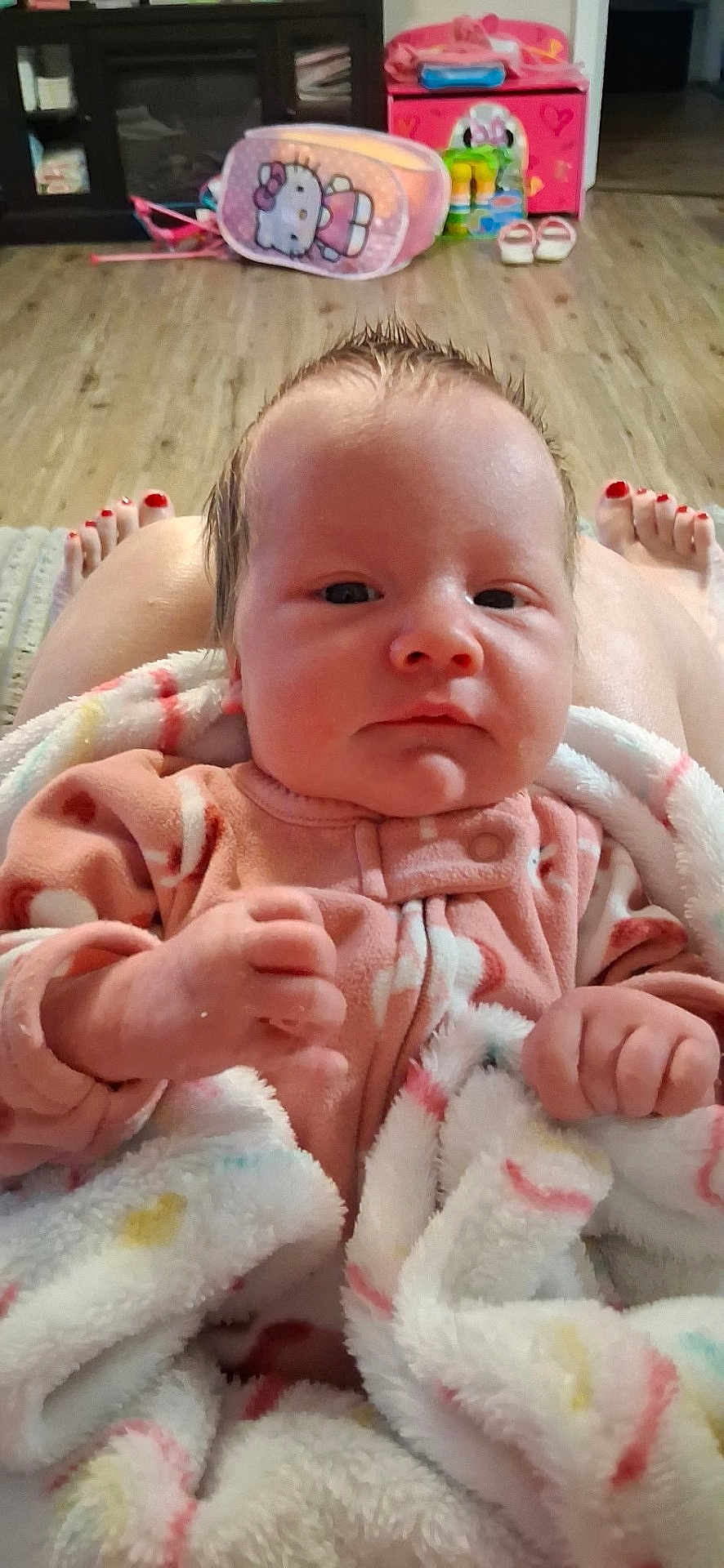 Layla Renee is registered to the contest to win money with this photo: baby, newborn, infant, blanket, onesie, pajamas, toes, painted_toenails, hello_kitty, backpack, toys, hardwood_floor, living_room, cabinet, shoes, portrait, cozy, hands, face, indoor