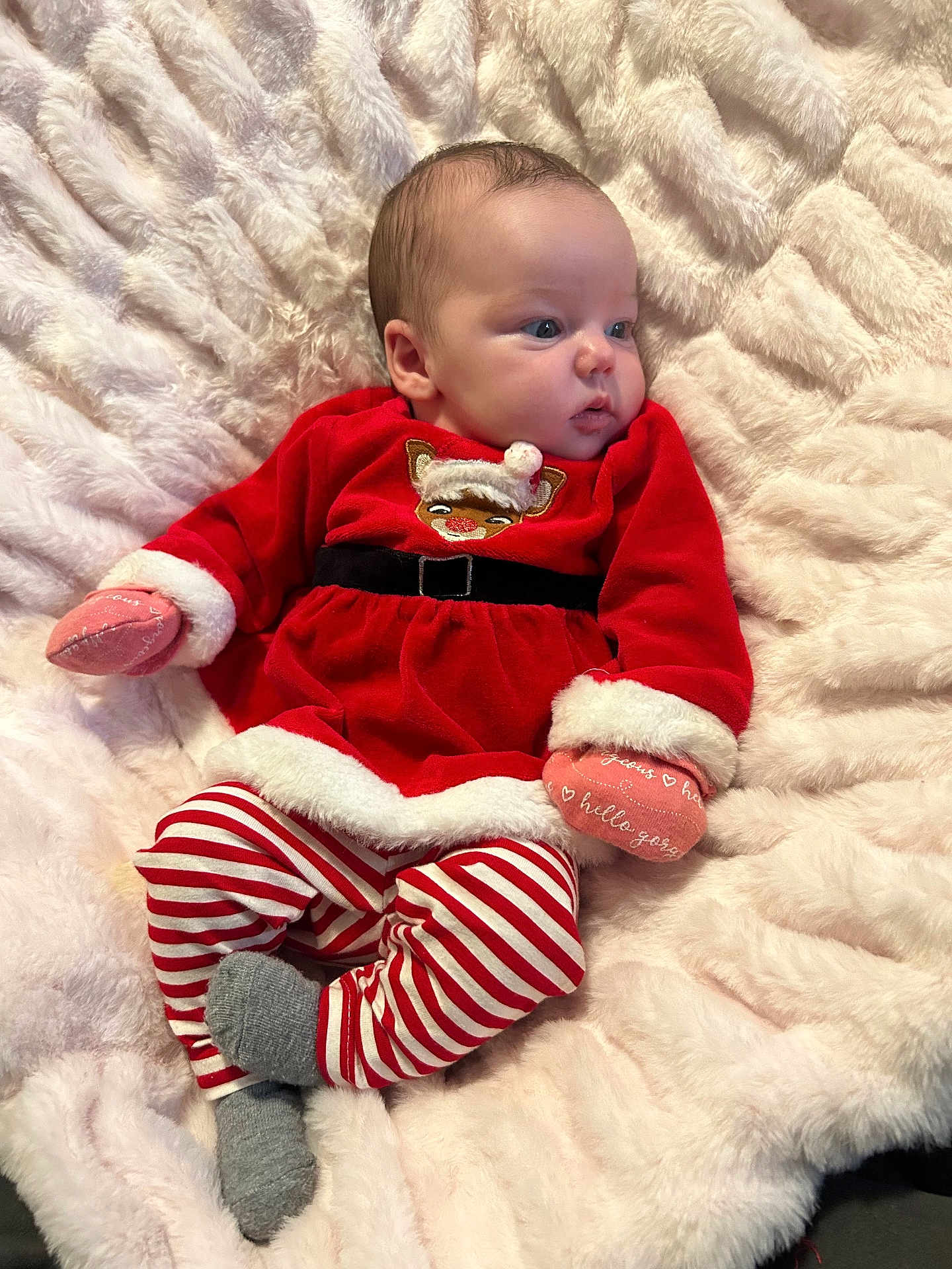 Lemailey is registered to the contest to win money with this photo: baby, infant, child, red_dress, striped_pants, mittens, reindeer, blanket, soft_texture, cozy, cute, holiday_clothing, portrait, indoors, laying_down, person, young_child, warm, comfort, expression
