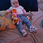 Lemailey is registered to the contest to win money with this photo: baby, bed, blanket, casual_clothing, child, comfort, cuddly_toy, cute, indoor, infant, jeans, person, pillow, plush_toy, relaxed, resting, sneakers, soft_lighting, white_shirt, young_child