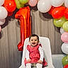 baby, child, birthday, balloons, chair, celebration, number_one, red_dress, white_tights, smiling, happy, indoor, party, decorations, colorful, festive, toddler, portrait, cute, event