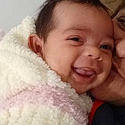 Cataleya participe au concours pour gagner de l'argent avec cette photo : baby, smiling, face, blanket, fluffy, happy, child, person, closeup, expression, affection, kissing, warm, cozy, indoor, portrait, cute, skin, head, infant