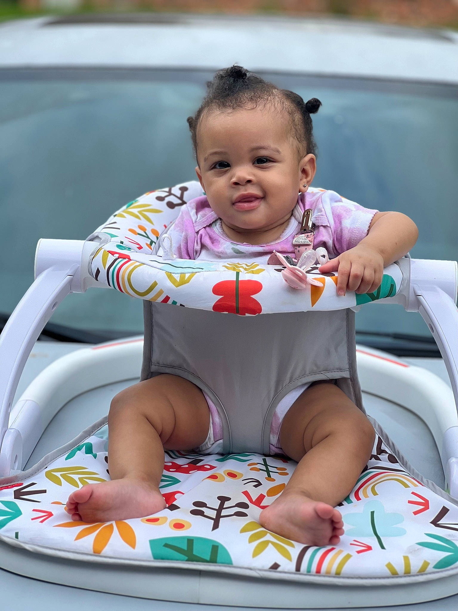 Gia is registered to the contest to win money with this photo: automotive_exterior, baby, baby_products, baby_toddler_clothing, bumper, child, fun, grass, happy, leisure, person, pink, product, recreation, sandal, sitting, skin, thigh, toddler, vacation