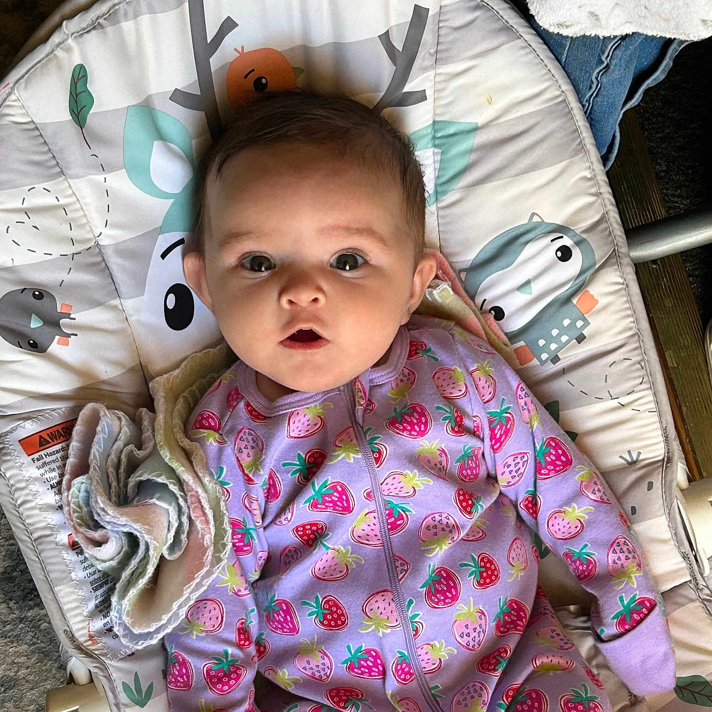 Violett is registered to the contest to win money with this photo: baby, infant, onesie, strawberry_pattern, baby_seat, cushion, face, expression, wide_eyes, soft_toy, blanket, indoor, child, clothing, comfort, cute, light_shadow, animal_print, pink, purple