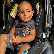 Ezra is registered to the contest to win money with this photo: child, toddler, car_seat, smiling, happy, seatbelt, baby, clothing, shorts, shirt, car_interior, safety, cute, portrait, infant, young_child, seat, strapped_in, automobile, baby_boy