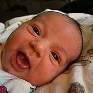 Wrenley joined the competition — help win amazing prizes! baby, infant, face, smile, tongue, blanket, pineapple_pattern, clothing, indoor, close_up, person, cute, happy, skin, head, newborn, expression, soft, lying_down, warm