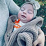 Wrenley joined the competition — help win amazing prizes! baby, sleeping, knit_sweater, headband, bow, adult_hand, outdoor, grass, fall_leaves, cozy, child, person, warm_clothing, closeup, portrait, peaceful, resting, soft_texture, casual_wear, nature