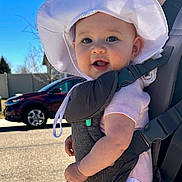 Harper joined the competition — help win amazing prizes! adult_partial, baby, baby_carrier, blue_sky, candid, car, cheeks, child, closeup, eyes, hat_brim, infant, outdoors, parent, portrait, sidewalk, smile, straps, sun_hat, sunny