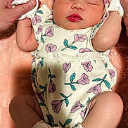 Harper is registered to the contest to win money with this photo: baby, infant, sleeping, onesie, headband, bow, mittens, socks, hands, blanket, soft_texture, floral_pattern, cute, peaceful, newborn, person, child, indoors, closeup, resting
