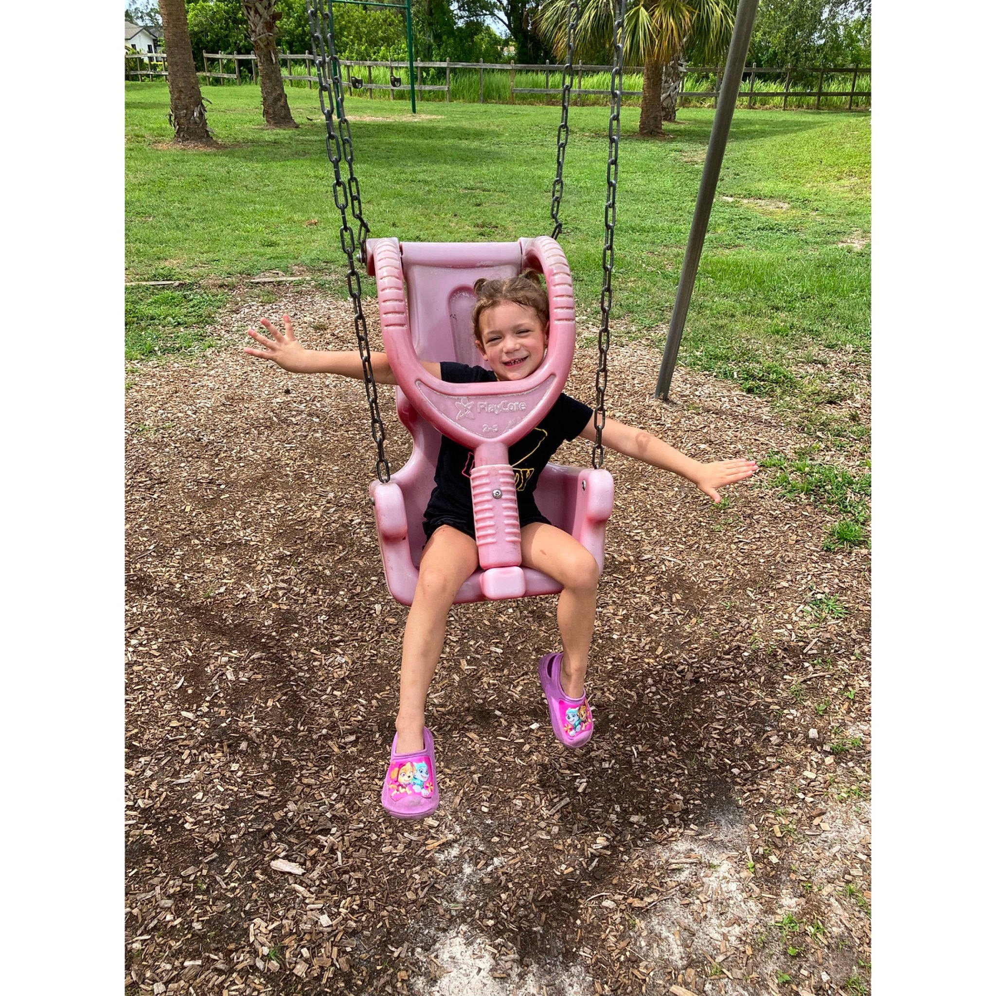 Everly is registered to the contest to win money with this photo: baby, baby_toddler_clothing, city, fun, grass, happy, joy, leisure, magenta, outdoor_play_equipment, people_in_nature, person, plant, play, playground, recreation, shorts, sitting, soil, swing