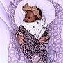 animal_slippers, baby, baby_seat, bow, child, cozy, cushion, cute, headband, indoors, infant, leopard_print, onesie, patterned_fabric, peaceful, portrait, resting, sleeping, slippers, young_child