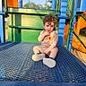 toddler, child, playground, curly_hair, winnie_the_pooh, shirt, blue_platform, orange_slide, green_railings, outdoor, sunlight, shadow, summer, playing, park, metal_surface, casual_clothing, cute, sitting, daytime