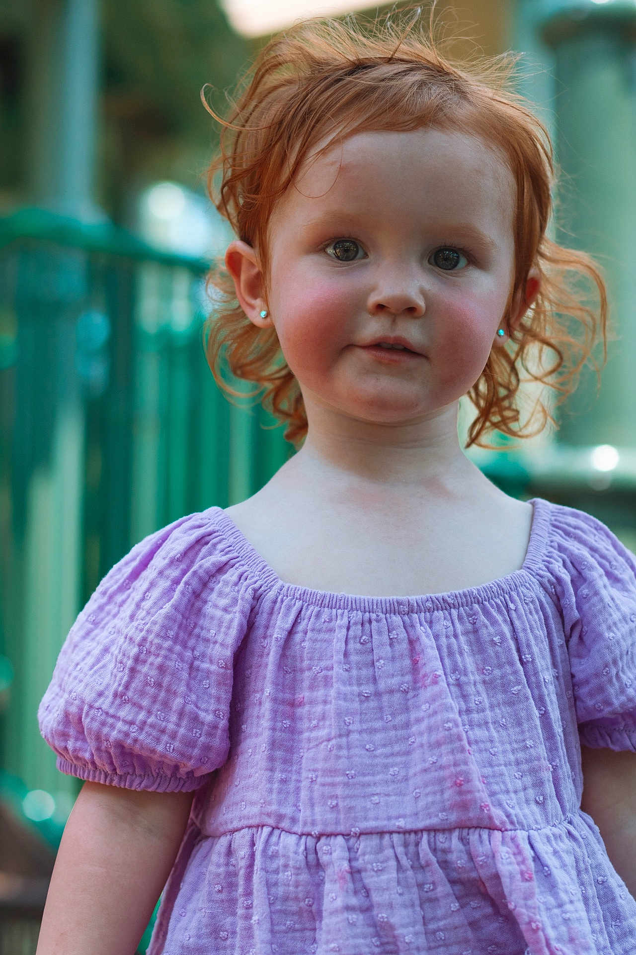 Adalyne is registered to the contest to win money with this photo: child, red_hair, curly_hair, lavender_dress, earrings, rosy_cheeks, portrait, outdoor, natural_light, young_child, cute, smiling, innocent, face, person, fashion, summer, childhood, happy, eyes