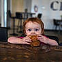 Adalyne joined the competition — help win amazing prizes! toddler, child, muffin, food, table, red_hair, indoor, cafe, eating, hands, face, plate, person, childhood, snack, curly_hair, brown_wood, blurred_background, cute, young