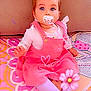 baby, pacifier, pink_dress, tights, sitting, blanket, patterned_blanket, child, indoors, cute, heart_doodle, flower_emoji, blue_eyes, short_hair, infant, playful, colorful, soft_toys, baby_girl, portrait