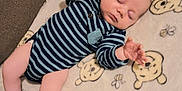 Charles is registered to the contest to win money with this photo: baby, bear_faces, bees, blanket, child, cozy, cute, hand, human, indoor, infant, legs, newborn, pajamas, peaceful, person, resting, sleeping, soft_texture, striped_clothing