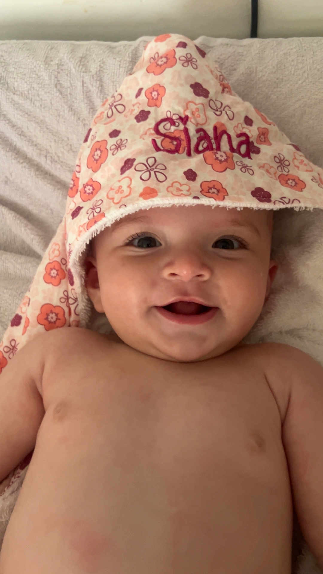 Siana a rejoint le concours — aidez-le/la à gagner de superbes lots ! baby, child, smiling, towel, floral_pattern, embroidery, face, skin, lying_down, blanket, headwear, cute, happy, infant, indoors, closeup, young_child, portrait, soft_texture, comfort