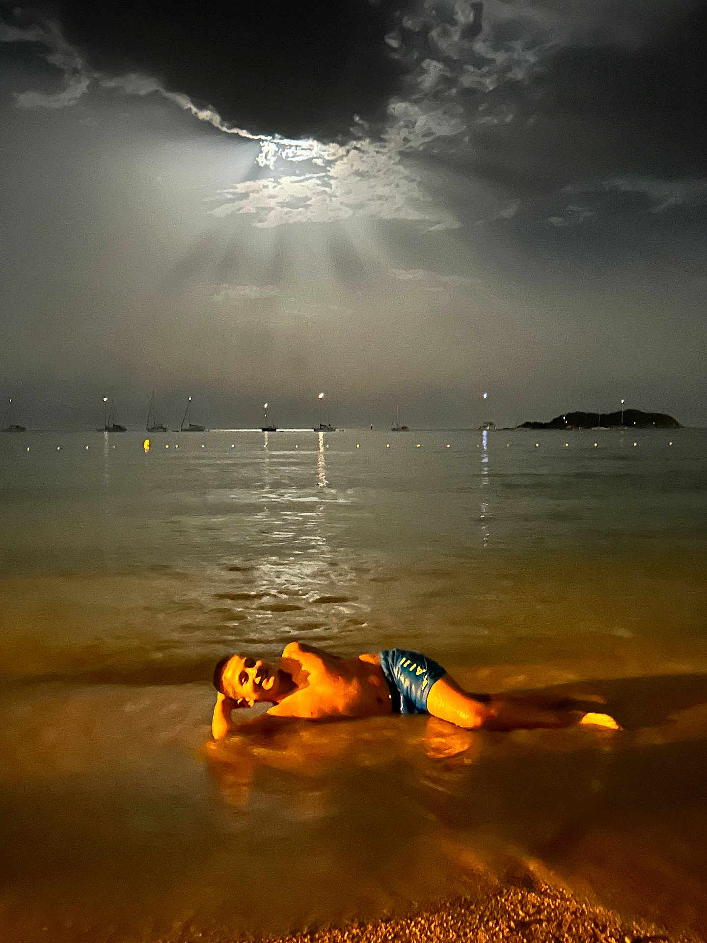 Matthias participe au concours pour gagner de l'argent avec cette photo : boy, night, beach, water, moonlight, clouds, boats, sand, shore, reflection, swimwear, relaxing, outdoor, darkness, sky, waterfront, vacation, holiday, sea, young