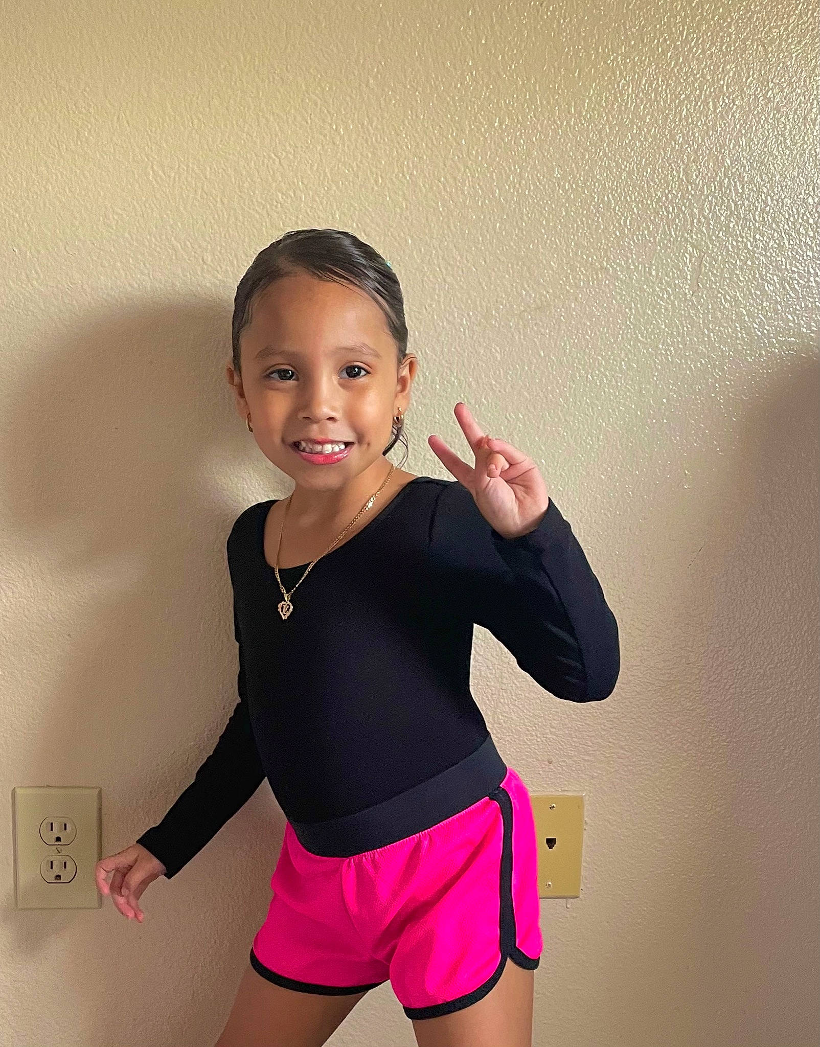 Emma is registered to the contest to win money with this photo: baby_toddler_clothing, clothing, face, flash_photography, gesture, hair, happy, head, human_body, joint, joy, knee, leg, neck, person, shoulder, sleeve, smile, sportswear, t_shirt