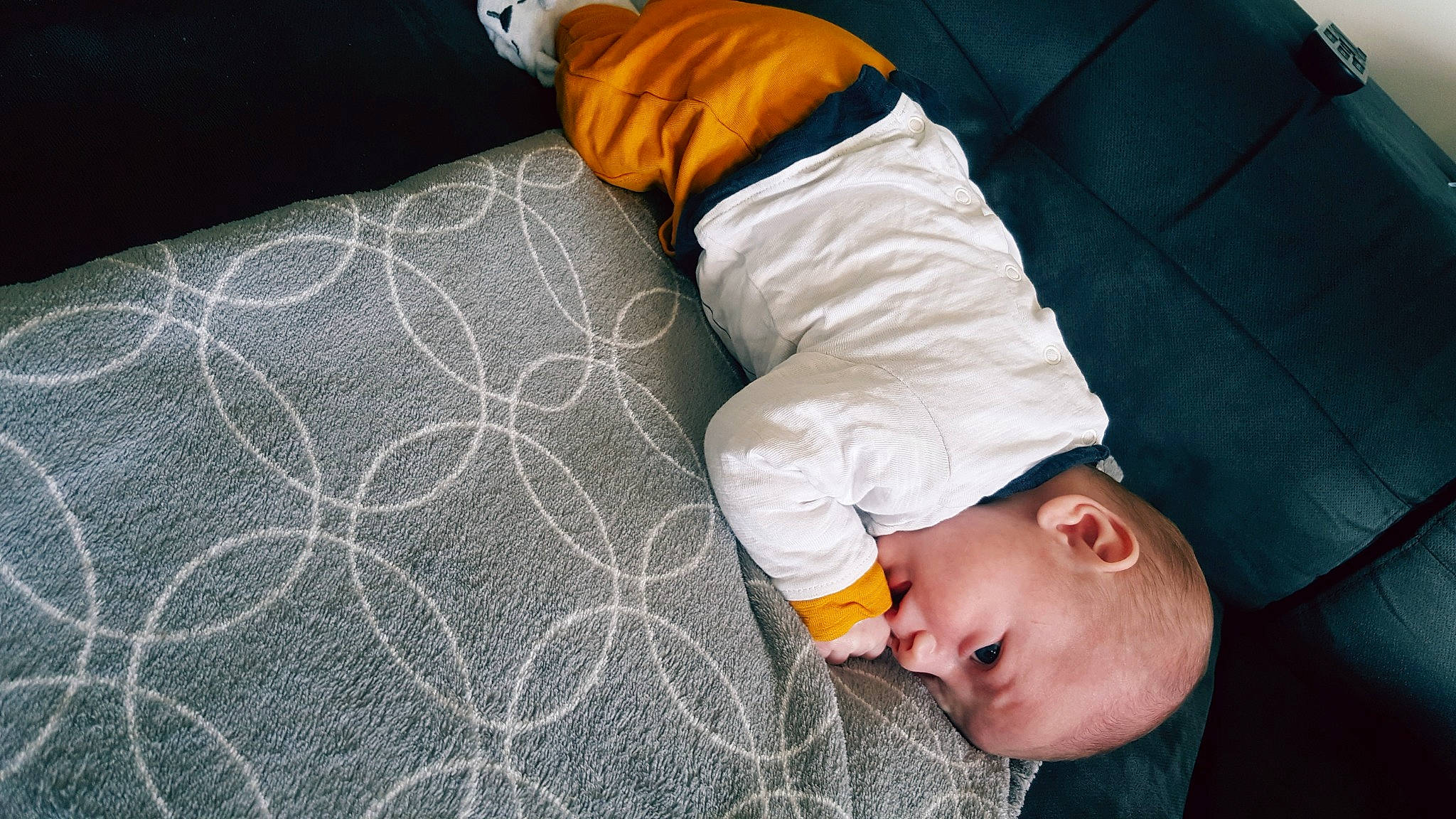 Cleyton participe au concours pour gagner de l'argent avec cette photo : baby, baby_products, baby_toddler_clothing, bedding, cap, child, clothing, comfort, flooring, linens, nap, orange, pattern, person, room, sitting, sleeve, t_shirt, textile, toddler