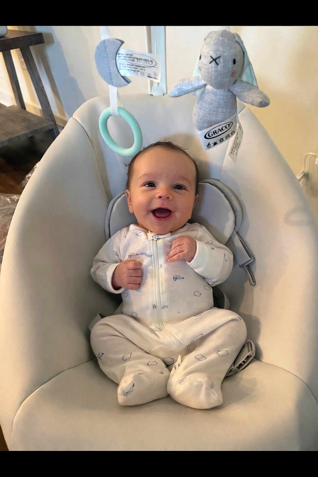 Odin is registered to the contest to win money with this photo: baby, infant, onesie, smile, happy, baby_seat, plush_toy, bunny, toy_ring, indoor, child, cute, face, person, comfort, home, soft, seat, infant_clothing, baby_accessory