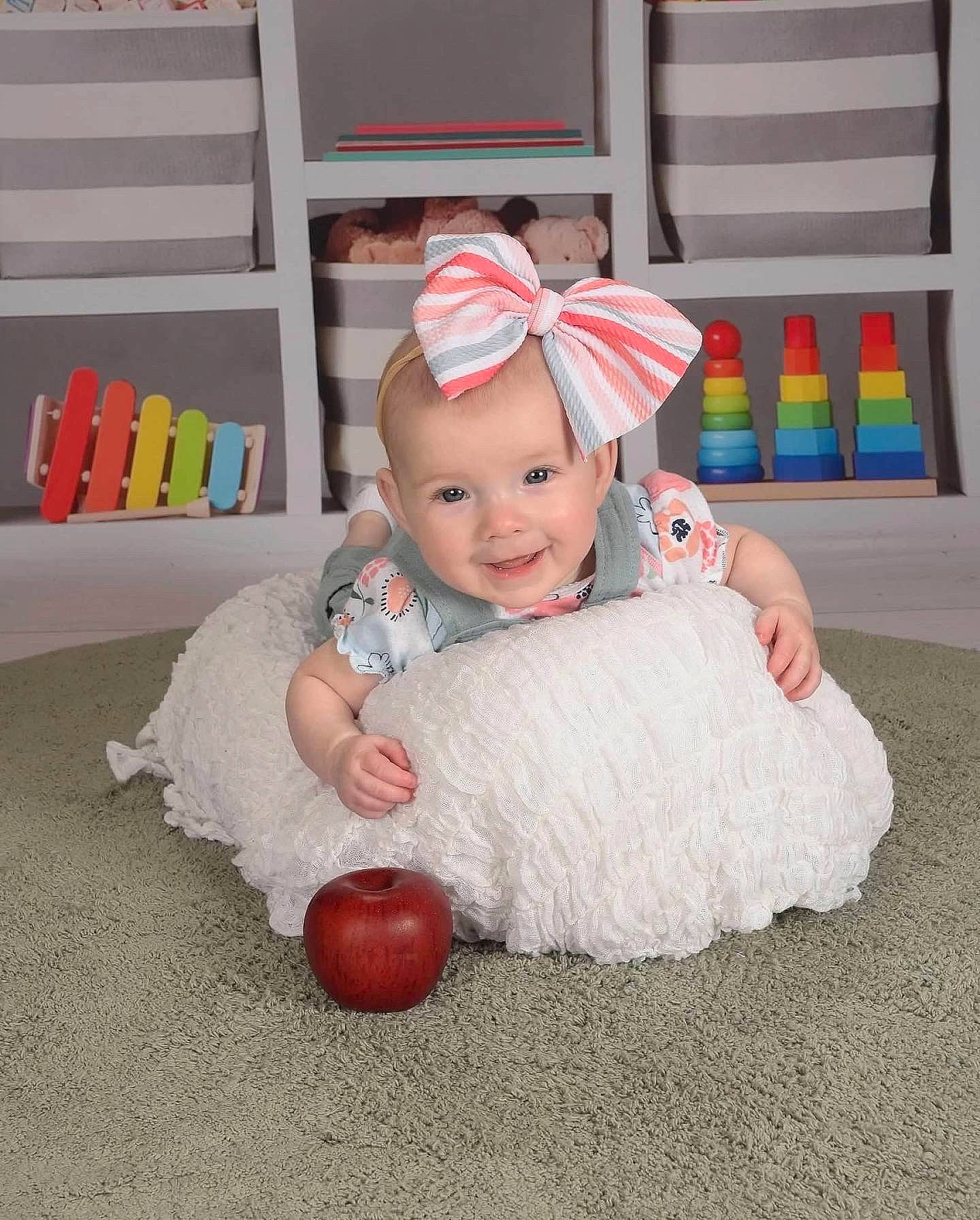 Kayleigh is registered to the contest to win money with this photo: baby, baby_toddler_clothing, carmine, child, event, face, floor, flooring, fun, happy, head, headgear, headwear, joy, party_supply, person, pink, room, sitting, smile