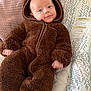 baby, child, onesie, brown, fluffy, cushion, patterned, smile, face, head, infant, clothing, cute, comfort, indoor, portrait, soft, relax, young, hood