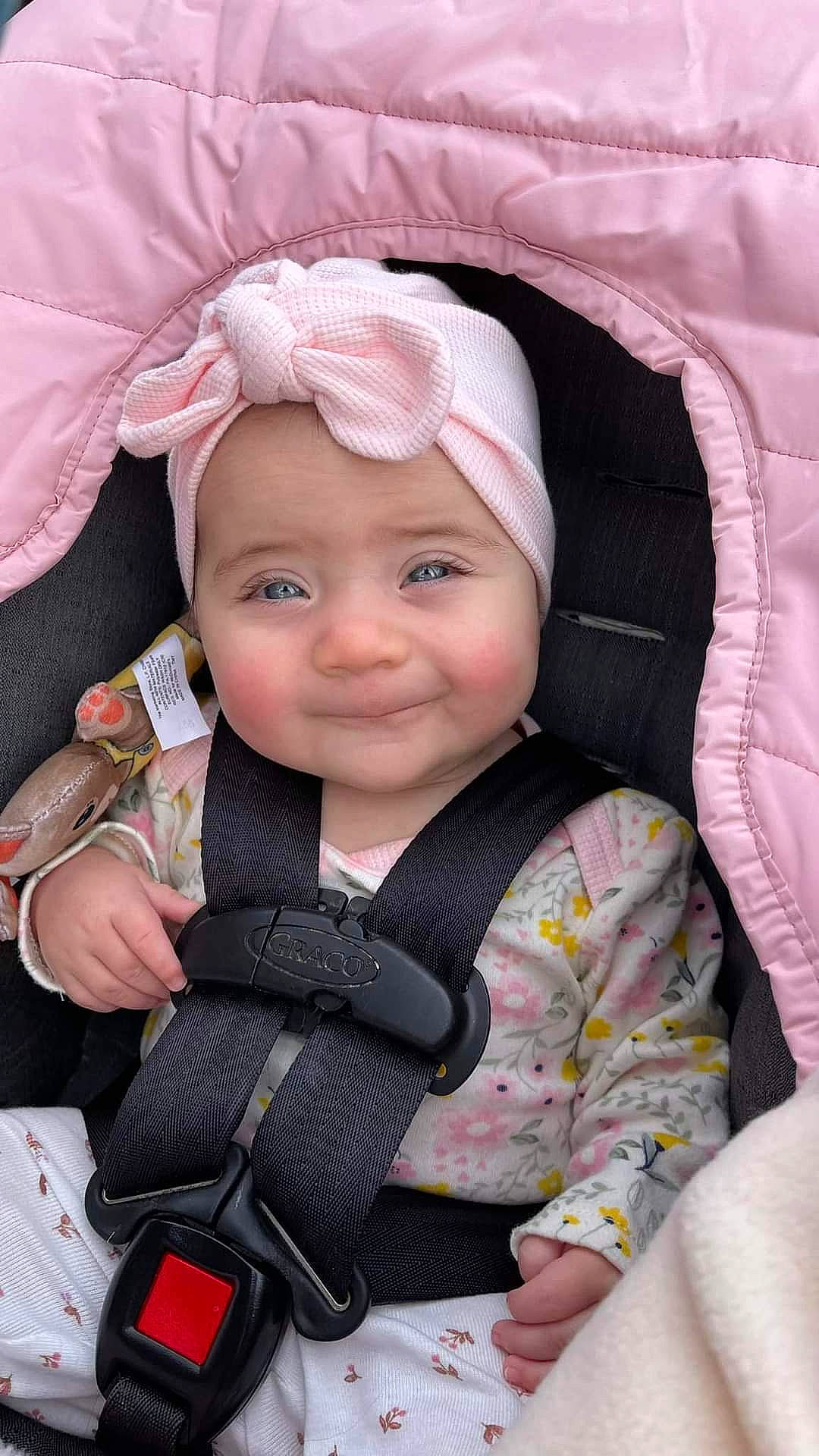 Penelope is registered to the contest to win money with this photo: baby, baby_carriage, baby_products, baby_safety, baby_toddler_clothing, cap, cheek, child, comfort, eye, eyebrow, fashion_accessory, happy, headwear, joy, magenta, person, pink, sitting, skin